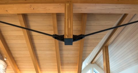 Timber ceiling with steel tension rods meeting at a steel connector below a king post